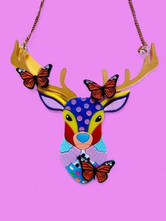 a necklace with a deer head and butterflies on it