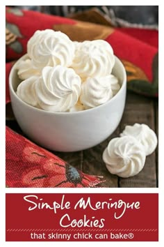 a white bowl filled with whipped cream on top of a wooden table next to a red cloth