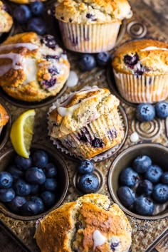 muffins with blueberries and lemon are sitting on a baking tray, ready to be eaten