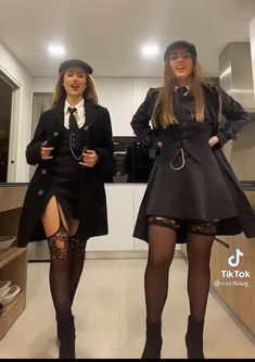 two women dressed in black are posing for the camera while standing next to each other