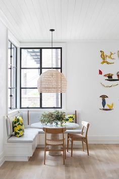 a dining room with white walls and wood flooring is decorated with birds on the wall