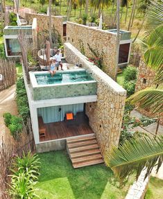 an aerial view of a house with a pool and hot tub in the yard, surrounded by palm trees