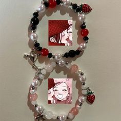 a bracelet with two pictures and charms on the front, along with a strawberry charm