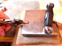 a person is using a pair of pliers to cut metal parts on a piece of fabric