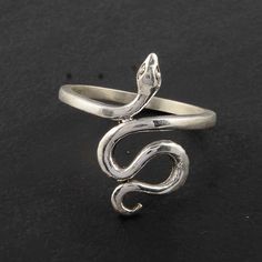 a silver snake ring sitting on top of a black surface