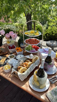 a picnic table with food and drinks on it, including fruit salads and sandwiches