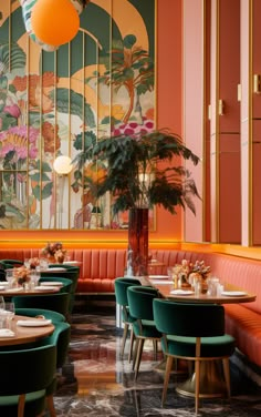 the interior of a restaurant with orange and green booths, round tables and colorful wallpaper