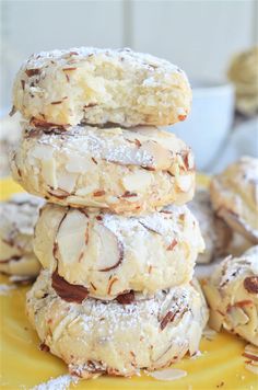 a stack of cookies sitting on top of a yellow plate covered in powdered sugar