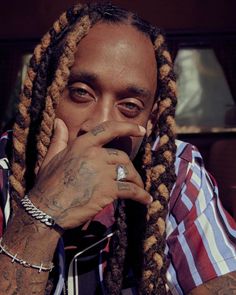 a close up of a person with dreadlocks and a ring on his finger