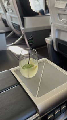 a drink in a glass on an airplane tray