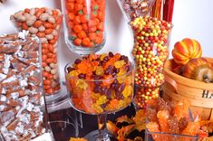 a table filled with lots of candy and candies on top of each other in glass containers