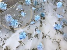 blue flowers and leaves on white fabric