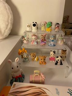 there are many small toy animals on the shelves in this room and one is white