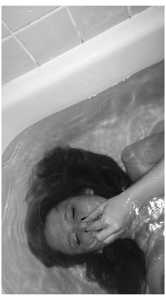 a woman laying down in a bath tub