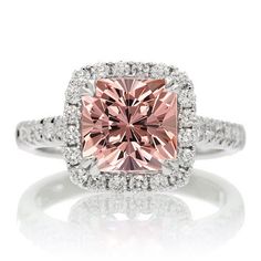 a pink diamond ring with diamonds around it