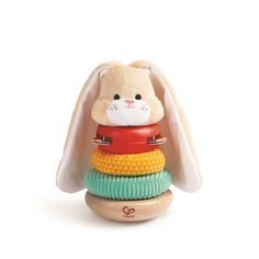 a small toy rabbit sitting on top of a stack of colorful toys