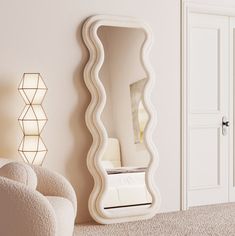 a large white mirror sitting on top of a wall next to a chair and lamp