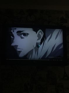 a tv screen with an anime character on it's face lit up in the dark