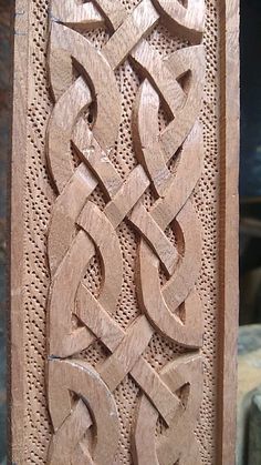 an intricate carving on the side of a wooden door, with knots and interlaces