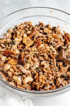 a glass bowl filled with granola and nuts