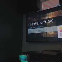 a flat screen tv sitting on top of a wooden table next to a laptop computer