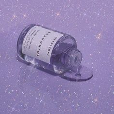 a bottle of water sitting on top of a purple surface with stars in the background