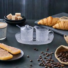 coffee and pastries on a table with croissants