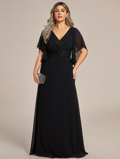 a woman wearing a black evening gown with sheer sleeves and an embellishment on the waist