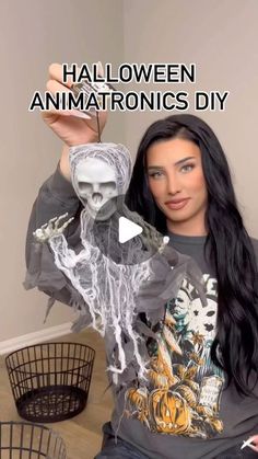 a woman sitting on top of a wooden floor next to a basket filled with halloween decorations