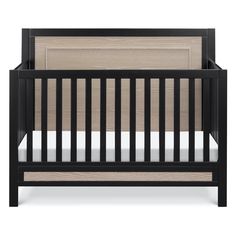 a black crib with wood paneling and white sheets on the bottom half, in front of a white background