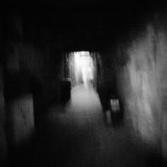 blurry photograph of people walking down a dark hallway