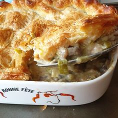 a casserole dish with meat and vegetables in it is being held by a fork