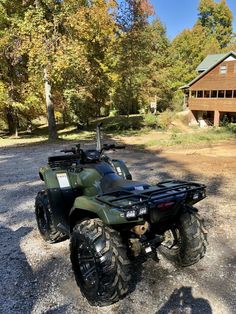 an atv parked in front of a log cabin