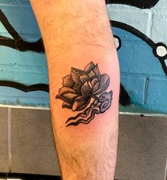 a man's leg with a tattoo on it that has a flower in the middle