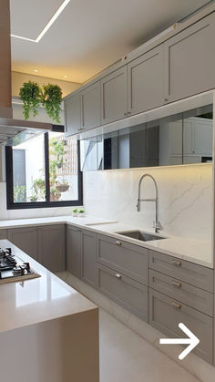 a kitchen with white counter tops and gray cabinets