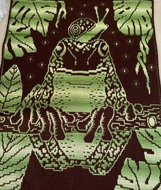 a green and black rug with an image of a frog on it's back