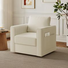 a white chair sitting in a living room next to a potted plant