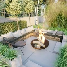 an outdoor fire pit surrounded by plants and trees