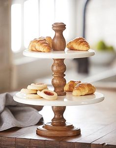 three tiered cake plate with croissants on it and two pastries