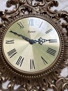 an ornate gold clock with roman numerals on it