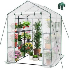 a green house with plants inside and flowers in the bottom tiers on each side