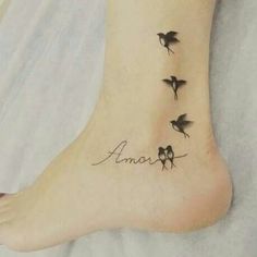 a woman's foot with three birds on it and the word love written in cursive writing