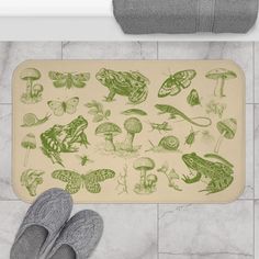 someone standing on the floor with their feet up in front of a bath mat that has various images of insects