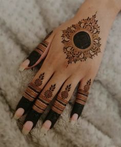 a woman's hand with henna tattoos on it