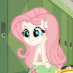 a pinkie is sitting on a table in front of some cupboards with green doors