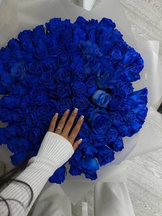 a woman holding a bouquet of blue roses