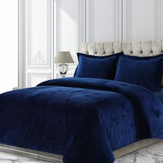 a blue comforter set in a white room