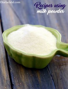 a green bowl filled with milk sitting on top of a wooden table