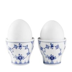 two blue and white egg cups sitting next to each other