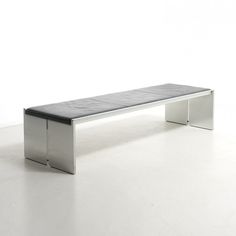 a metal bench sitting on top of a white floor